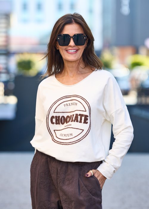 Biała bluzka damska Premium Chocolate z haftowanym napisem na przodzie, dekoltem w serek i luźnym fasonem do codziennych stylizacji.