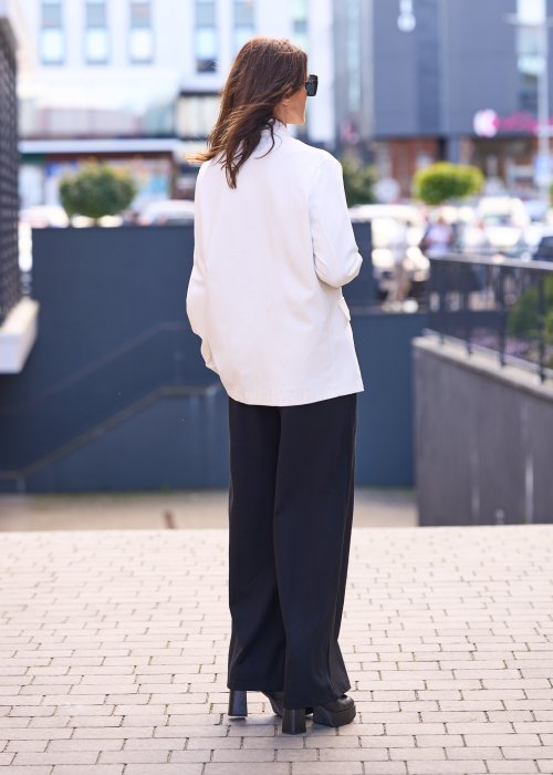 Stylowa, elegancka marynarka w odcieniu złamanej bieli, o nowoczesnym kroju bez klasycznego zapięcia.