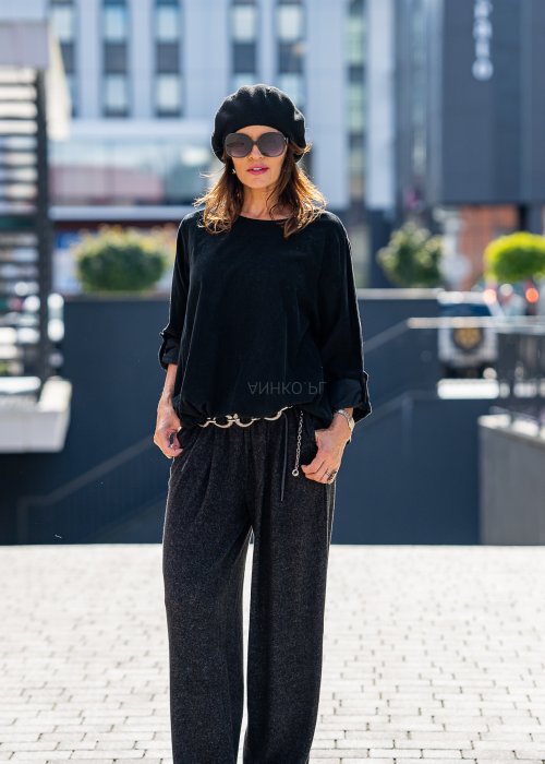 Czarna bluzka oversize z długim rękawem i regulowanym dołem, stylizowana z szerokimi spodniami i beretem w miejskim, minimalistycznym looku.