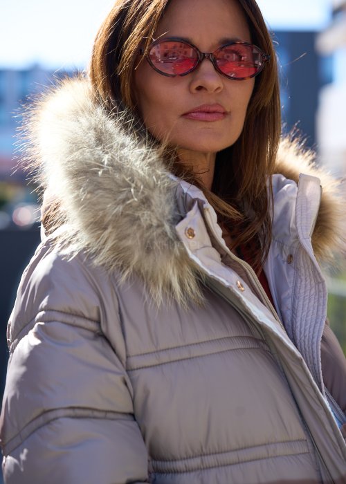 Długa pikowana kurtka z kapturem i futrzanym wykończeniem w kolorze taupe, ocieplana, z zamkiem i kieszeniami