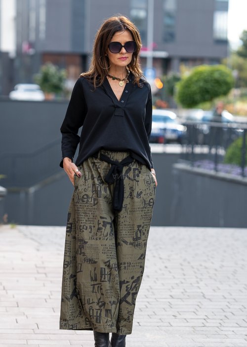 Czarna bluzka koszulowa damska z dekoltem V i długim rękawem o luźnym kroju. Stylizacja z szerokimi spodniami w miejskim, eleganckim stylu.