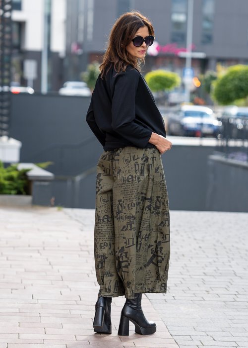 Czarna bluzka koszulowa damska z dekoltem V i długim rękawem o luźnym kroju. Stylizacja z szerokimi spodniami w miejskim, eleganckim stylu.