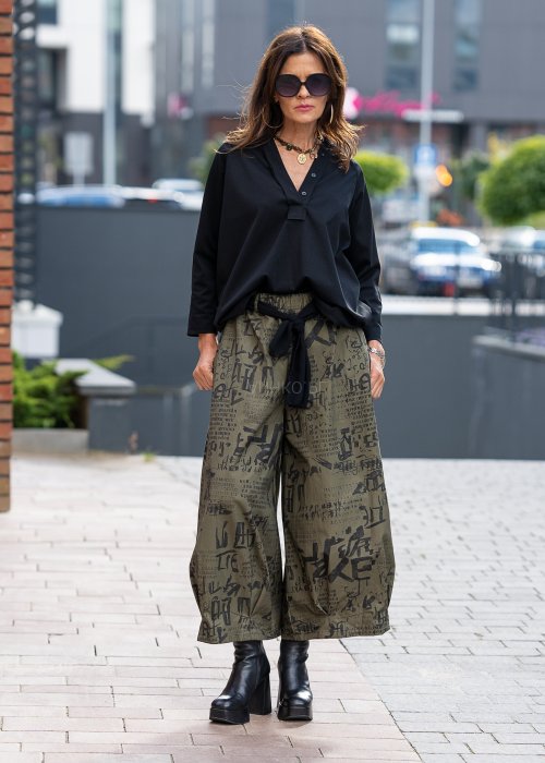 Czarna bluzka koszulowa damska z dekoltem V i długim rękawem o luźnym kroju. Stylizacja z szerokimi spodniami w miejskim, eleganckim stylu.