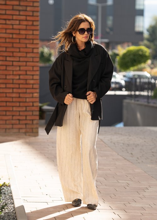 Czarny sweter oversize w stylu poncza z szerokim kołnierzem komin i luźnym krojem. Model w miejskiej stylizacji z eleganckim, minimalistycznym charakterem.