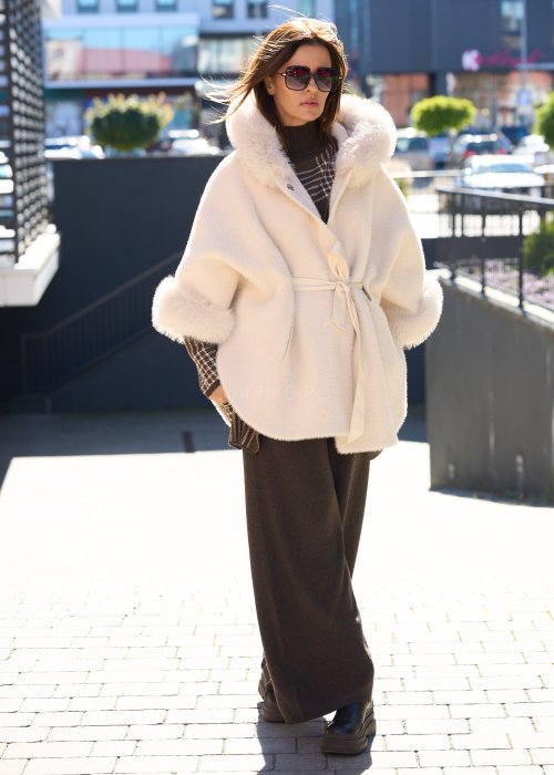 Krótka kurtka typu ponczo w kolorze ecru z kapturem i futrzanym wykończeniem rękawów