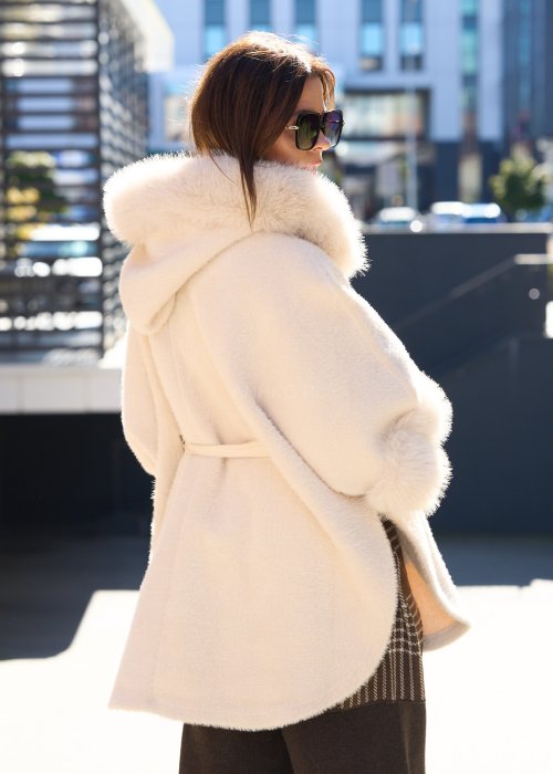 Krótka kurtka typu ponczo w kolorze ecru z kapturem i futrzanym wykończeniem rękawów