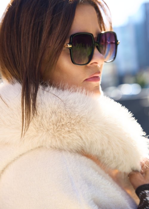 Krótka kurtka typu ponczo w kolorze ecru z kapturem i futrzanym wykończeniem rękawów