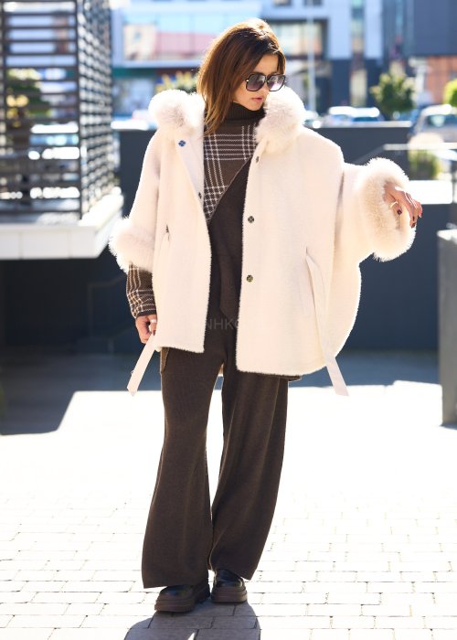 Krótka kurtka typu ponczo w kolorze ecru z kapturem i futrzanym wykończeniem rękawów