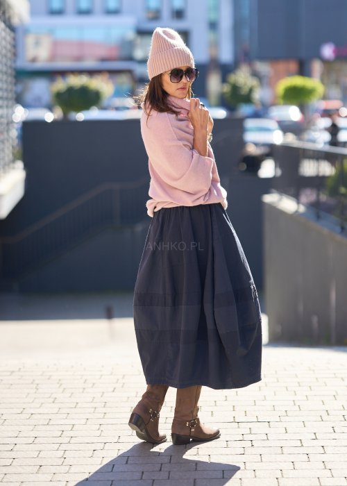 Sweter oversize w kolorze pudrowego różu z szerokim kołnierzem typu komin i luźnym krojem poncza. Model w miejskiej stylizacji, podkreślający miękką dzianinę i swobodny fason.