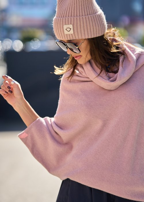 Sweter oversize w kolorze pudrowego różu z szerokim kołnierzem typu komin i luźnym krojem poncza. Model w miejskiej stylizacji, podkreślający miękką dzianinę i swobodny fason.