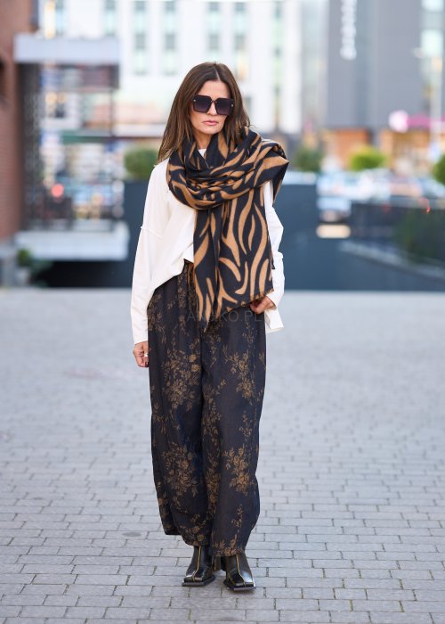 Ciemnogranatowe spodnie z szerokimi nogawkami, zdobione złotym roślinnym wzorem, zakończone gumką przy kostkach.