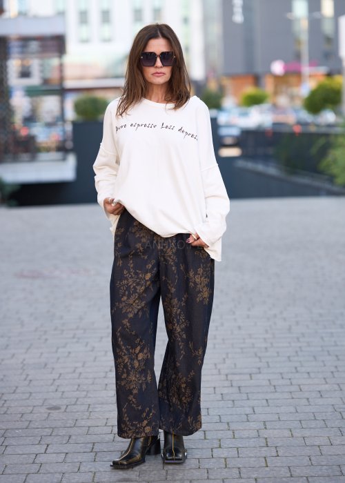 Ciemnogranatowe spodnie z szerokimi nogawkami, zdobione złotym roślinnym wzorem, zakończone gumką przy kostkach.