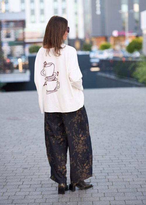 Ciemnogranatowe spodnie z szerokimi nogawkami, zdobione złotym roślinnym wzorem, zakończone gumką przy kostkach.