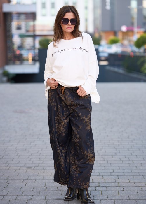 Ciemnogranatowe spodnie z szerokimi nogawkami, zdobione złotym roślinnym wzorem, zakończone gumką przy kostkach.