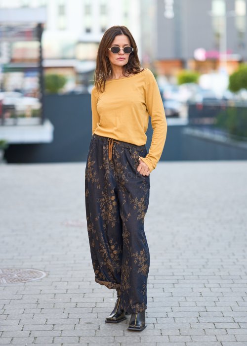 Ciemnogranatowe spodnie z szerokimi nogawkami, zdobione złotym roślinnym wzorem, zakończone gumką przy kostkach.