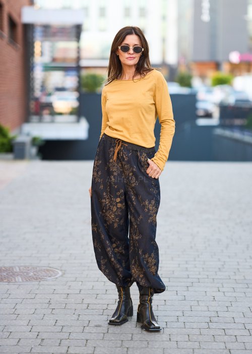 Ciemnogranatowe spodnie z szerokimi nogawkami, zdobione złotym roślinnym wzorem, zakończone gumką przy kostkach.