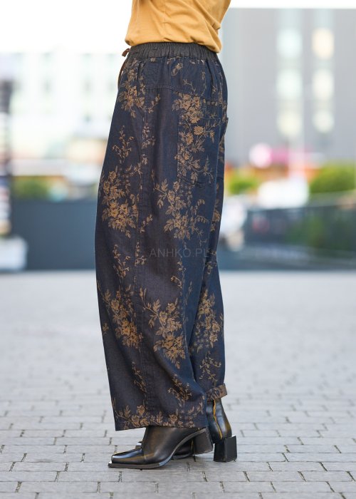 Ciemnogranatowe spodnie z szerokimi nogawkami, zdobione złotym roślinnym wzorem, zakończone gumką przy kostkach.