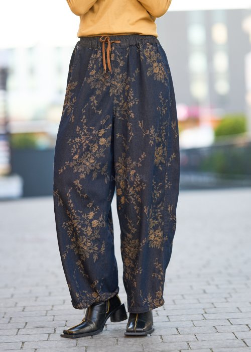 Ciemnogranatowe spodnie z szerokimi nogawkami, zdobione złotym roślinnym wzorem, zakończone gumką przy kostkach.