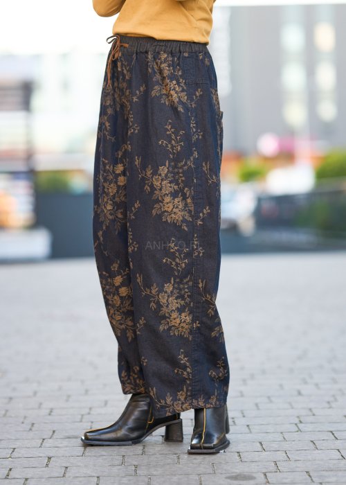 Ciemnogranatowe spodnie z szerokimi nogawkami, zdobione złotym roślinnym wzorem, zakończone gumką przy kostkach.