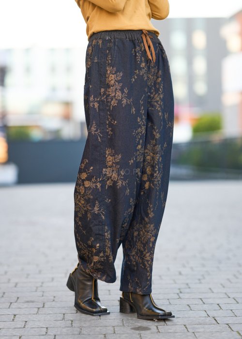 Ciemnogranatowe spodnie z szerokimi nogawkami, zdobione złotym roślinnym wzorem, zakończone gumką przy kostkach.