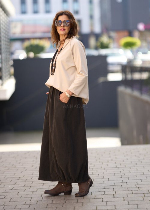 Beżowa koszula damska z długim rękawem i dekoltem zapinanym na guziki, wykonana z lekkiej tkaniny o luźnym kroju