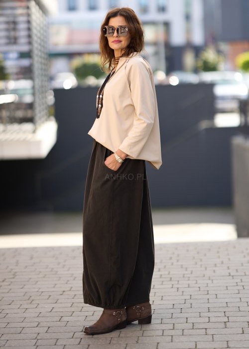 Beżowa koszula damska z długim rękawem i dekoltem zapinanym na guziki, wykonana z lekkiej tkaniny o luźnym kroju