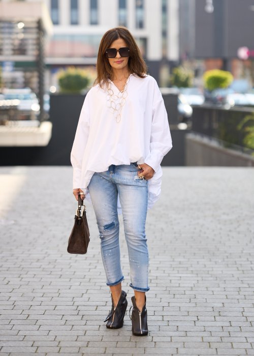 Jasnoniebieskie jeansy z przetarciami i dziurami na kolanach