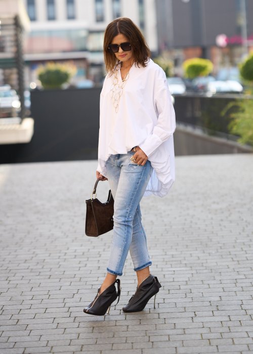 Jasnoniebieskie jeansy z przetarciami i dziurami na kolanach