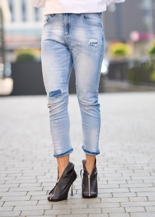 Jasnoniebieskie jeansy z przetarciami i dziurami na kolanach