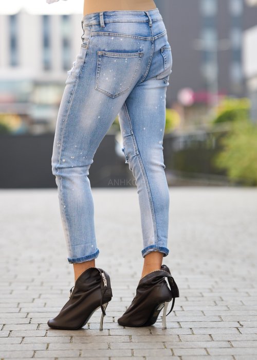 Jasnoniebieskie jeansy z przetarciami i dziurami na kolanach