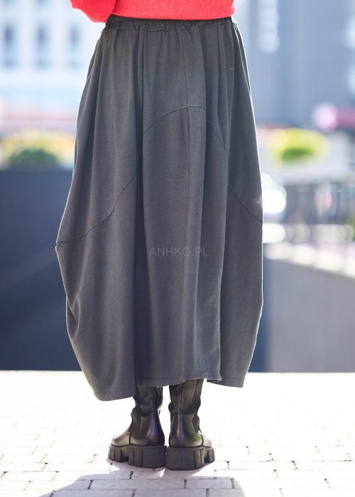 Antracytowa spódnica maxi typu bombka z elastycznym pasem i przeszyciami, zestawiona z czerwonym swetrem i czarnymi botkami w miejskiej stylizacji.