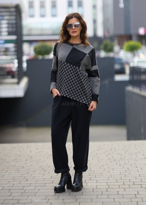 Czarne spodnie damskie o luźnym kroju z wysokim stanem i podwiniętymi nogawkami, wykonane z miękkiego materiału, styl casualowy