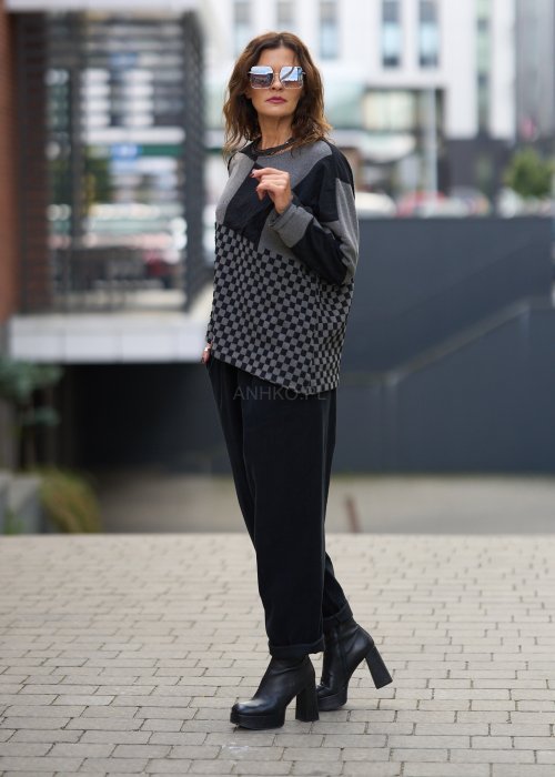 Czarne spodnie damskie o luźnym kroju z wysokim stanem i podwiniętymi nogawkami, wykonane z miękkiego materiału, styl casualowy