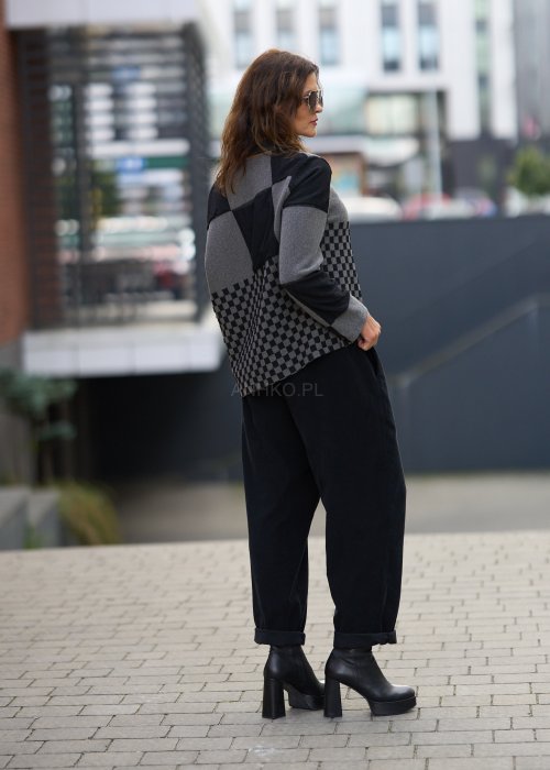 Czarne spodnie damskie o luźnym kroju z wysokim stanem i podwiniętymi nogawkami, wykonane z miękkiego materiału, styl casualowy