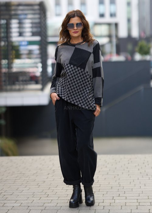 Czarne spodnie damskie o luźnym kroju z wysokim stanem i podwiniętymi nogawkami, wykonane z miękkiego materiału, styl casualowy