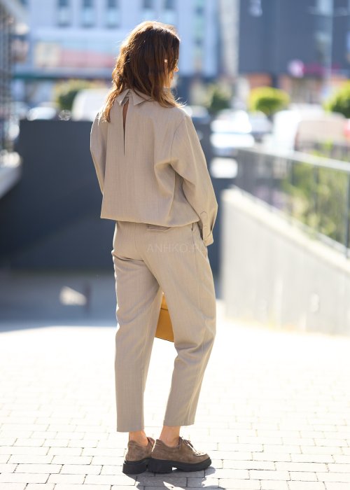 Beżowy komplet z prostą bluzką o luźnym kroju i długich rękawach oraz dopasowanymi spodniami z wysokim stanem