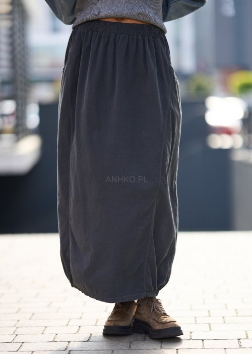 Grafitowa spódnica maxi z elastyczną talią i kieszeniami, o luźnym kroju, zestawiona z krótkim swetrem i brązowymi półbutami w miejskiej stylizacji.