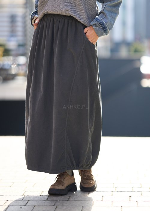 Grafitowa spódnica maxi z elastyczną talią i kieszeniami, o luźnym kroju, zestawiona z krótkim swetrem i brązowymi półbutami w miejskiej stylizacji.
