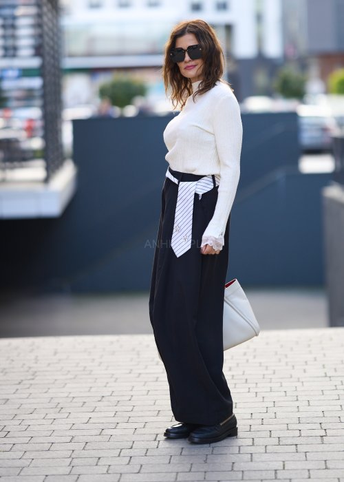 Czarne spodnie damskie z szeroką nogawką typu palazzo, z ozdobnym paskiem w talii i kieszeniami, styl elegancki