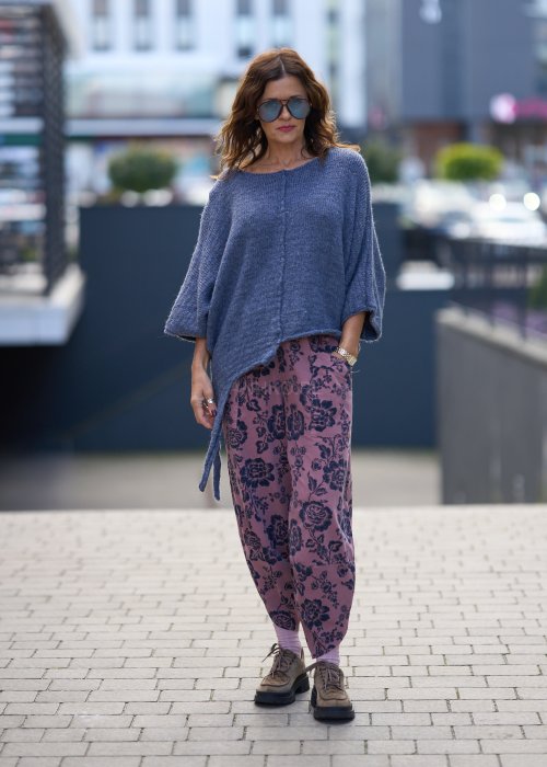 Różowe spodnie damskie z luźną nogawką i czarnym kwiatowym wzorem, wykonane z lekkiego materiału z kieszeniami