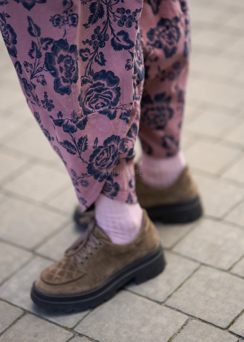 Różowe spodnie damskie z luźną nogawką i czarnym kwiatowym wzorem, wykonane z lekkiego materiału z kieszeniami