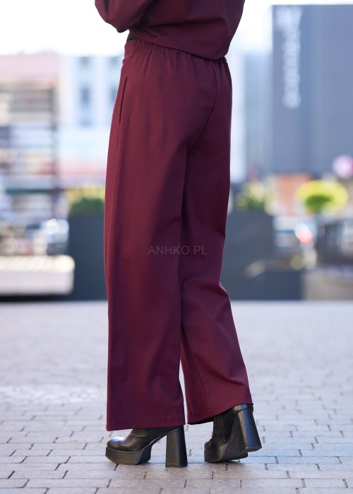 Śliwkowe spodnie damskie z prostą nogawką i wysokim stanem, zapinane na duży ozdobny guzik, wykonane z miękkiej, eleganckiej tkaniny