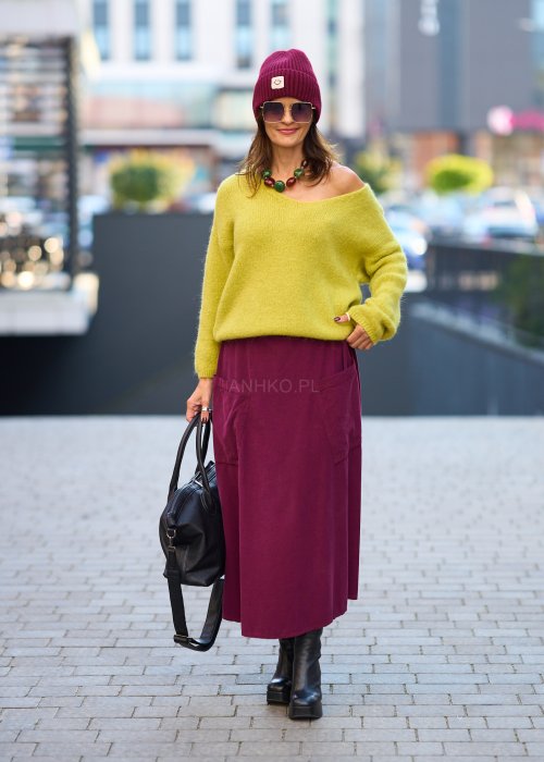 Śliwkowa spódnica sztruksowa midi z naszywanymi kieszeniami i elastycznym pasem, zestawiona z limonkowym swetrem i czarnymi botkami w miejskiej stylizacji.