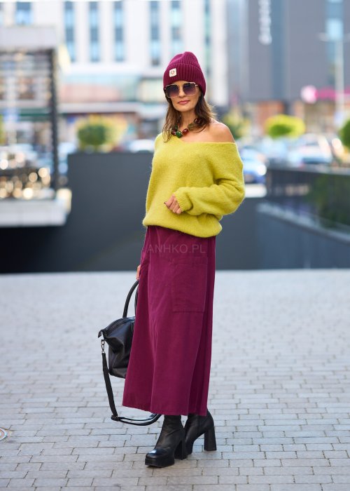 Śliwkowa spódnica sztruksowa midi z naszywanymi kieszeniami i elastycznym pasem, zestawiona z limonkowym swetrem i czarnymi botkami w miejskiej stylizacji.