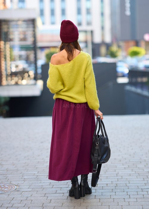Śliwkowa spódnica sztruksowa midi z naszywanymi kieszeniami i elastycznym pasem, zestawiona z limonkowym swetrem i czarnymi botkami w miejskiej stylizacji.