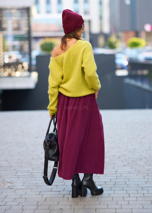 Śliwkowa spódnica sztruksowa midi z naszywanymi kieszeniami i elastycznym pasem, zestawiona z limonkowym swetrem i czarnymi botkami w miejskiej stylizacji.