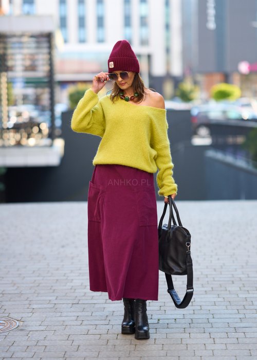 Śliwkowa spódnica sztruksowa midi z naszywanymi kieszeniami i elastycznym pasem, zestawiona z limonkowym swetrem i czarnymi botkami w miejskiej stylizacji.