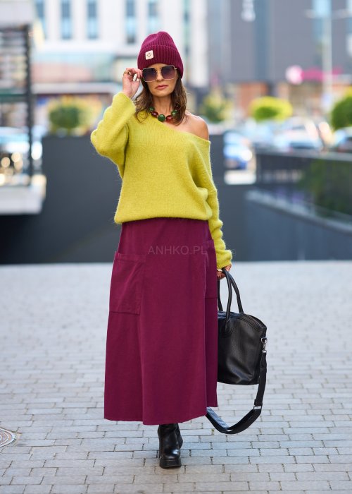 Śliwkowa spódnica sztruksowa midi z naszywanymi kieszeniami i elastycznym pasem, zestawiona z limonkowym swetrem i czarnymi botkami w miejskiej stylizacji.