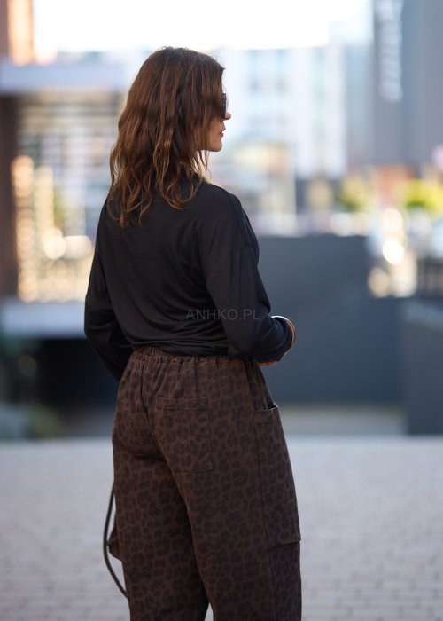 Czarna bluzka damska z długim rękawem i stójką, o luźnym kroju, w minimalistycznym stylu fashion