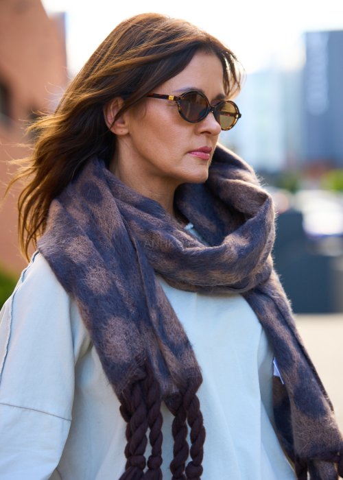 Miękki szal z motywem panterki, zakończony grubymi, plecionymi frędzlami.